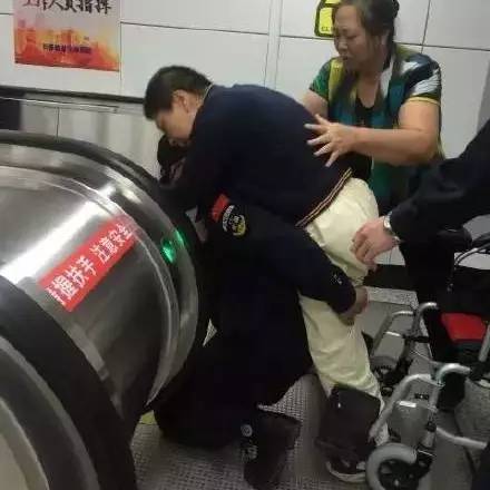 保安員背殘障男子上扶梯